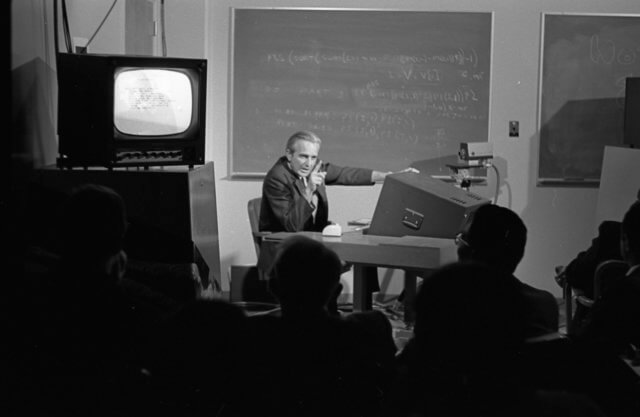 Photo of Doug Engelbart in front of his NLS